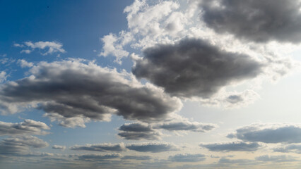 Wall Mural - beautiful blue sky with dark dramatic cumulus clouds and sunlight for abstract background