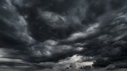 Wall Mural - dark dramatic sky with black stormy clouds before rain or snow as abstract background, extreme weath