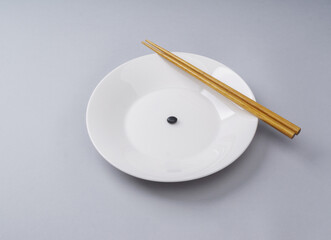 Sticker - Close-up of a Seoritae(black beans) with wood chopsticks on white dish, South Korea
