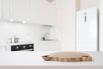 Wall Mural - wooden podium on white table with free space and blurred modern kitchen interior background