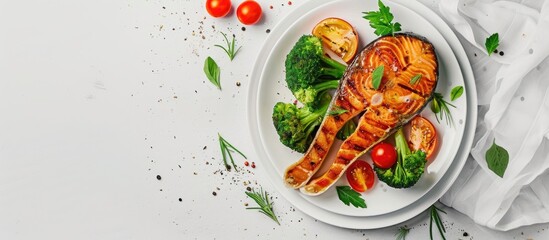 Wall Mural - Diet food concept with a grilled salmon steak broccoli and tomatoes on a white plate against a gray copy space image