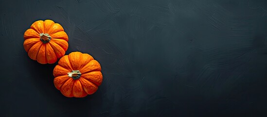 Poster - Autumn themed top view composition featuring two vivid orange pumpkins placed on a dark background for Halloween offering a perfect copy space image