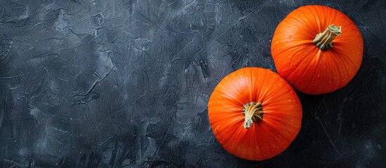 Poster - Autumn themed top view composition featuring two vivid orange pumpkins placed on a dark background for Halloween offering a perfect copy space image