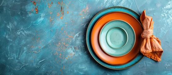 Poster - A blue concrete background showcases a table setting including a plate and napkin seen from a top down perspective ideal for a copy space image