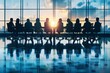 © Jiraphat - A group of people in silhouette are seated around a conference table in a modern office, looking out at the sunset through large windows