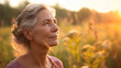 © Mirjana - Mature woman with gray hair contemplates in a meadow at sunset