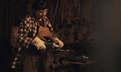 Welder, factory and metal worker woman with grinder and industrial machine in warehouse of blacksmith. Steel, labor and professional with welding skills and gear with manufacturing and maintenance