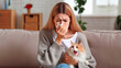 © Cliff - Young woman with cat allergy sneezes indoors due to allergic reaction at home