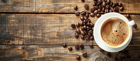 Poster - Top view of a coffee cup and beans on a wooden table with background suitable for additional text or graphics commonly known as copy space image