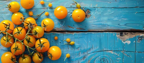 Poster - Top view of a blue wooden table adorned with ripe yellow tomatoes providing ample copy space image