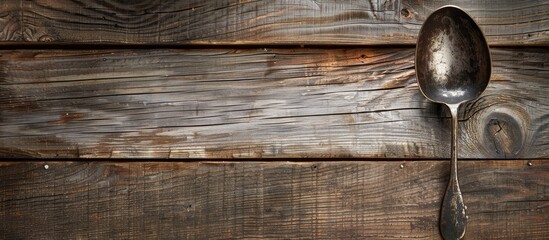 Poster - Cooking concept illustrated with a spoon resting on a wooden surface showing a rustic texture with ample copy space image