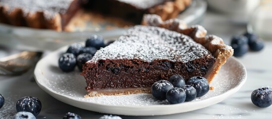 Poster - Close up horizontal image of chocolate pie in a white plate garnished with blueberries and powdered sugar featuring copy space image