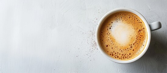 Poster - Close up top view of a white coffee cup with a foam fondue perfect for cappuccino or latte against a copy space image