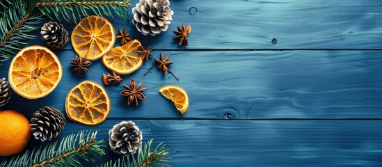 Fototapete - Christmas themed flat lay featuring handmade decorations like pine cones and dried oranges on a blue wooden backdrop with copy space image