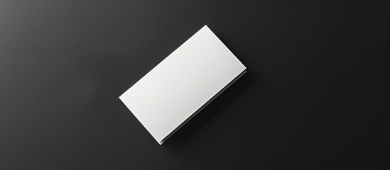 Fototapete - Top view of a business card elegantly displayed against a black backdrop with empty space ready for customization or text placement. Creative banner. Copyspace image
