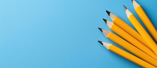 Aufkleber - Aerial view of yellow pencils and blank paper against a blue backdrop with copy space image