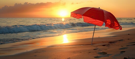 Poster - Beach umbrella providing shade on the sandy shore during sunset with copy space image