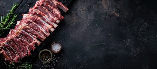 Poster - A butcher table displaying a raw rack of lamb ribs with a dark background in a top view Ample copy space for customization in the image