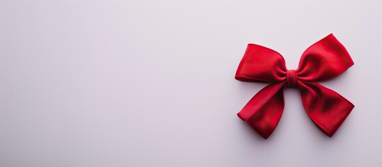 Fototapete - Close up shot of a red bow on a white background with copy space image