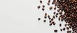 © HN Works - Coffee grains seen in a copy space image on a white surface