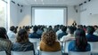 © CK Studio - Diverse audience attending a seminar in a modern conference room, focused on a large projection screen.