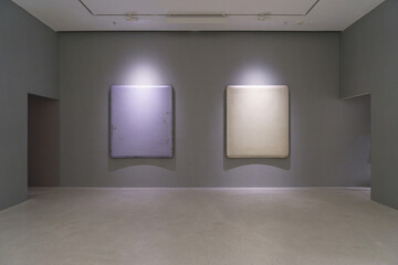 Hong Kong, China - March 13, 2015: Interior of two square artworks on the grey wall of in the gallery with illumination
