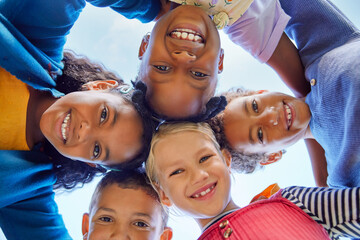 group of multiethnic children standing in a circle with their heads together