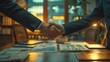© MangosteenStudio - Photo of a bank officer and a small business owner shaking hands after a successful loan application in a modern office The setting includes a desk with documents and financial cha