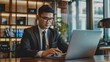 © ASGraphicsB24 - Young Asian businessman working on laptop computer in modern office.