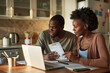 © Алена Ваторина - Couple reviewing finances with laptop in kitchen