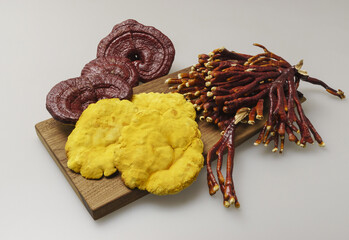 Poster - Close-up of three types of dried mushrooms like Phellinus linteus, Reishi mushroom and Antler ganoderma lucidum on wood plate, South Korea
