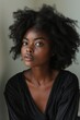© Tor Gilje - Elegant young African woman with natural curly hair and a soft gaze, posing in a minimalist setting, wearing a stylish black top.