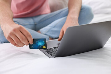 Canvas Print - Online banking. Man with credit card and laptop paying purchase at home, closeup