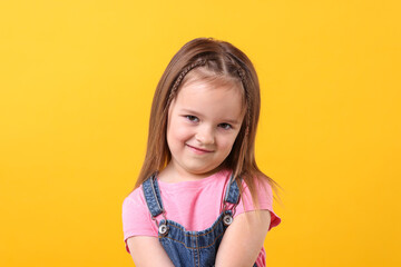 Wall Mural - Portrait of cute little girl on orange background