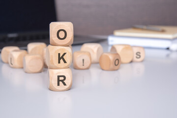 Poster - illustration of Objectives and Key Results concept using wooden blocks with an office background