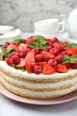 Canvas Print - Tasty sponge cake with fresh berries and mint on light gray table, closeup