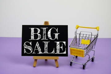 Wall Mural - Big Sale text message and trolley shopping cart on purple background