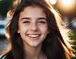 © Iuliia - A portrait of young woman with long brown hair, smiling brightly. The sun shines on her face, highlighting her white teeth and happy expression. Brown eyes, dark skin, tousled dark hair. AI generated