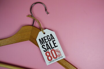 Wall Mural - Mega Sale 80% on price tag with wooden clothes hanger top view on pink background