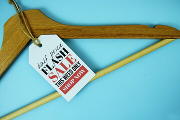 Wall Mural - Flash Sale on price tag with wooden clothes hanger top view on blue background