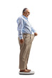 © Ljupco Smokovski - Mature man trying on an old pair of pants and standing on a weight scale