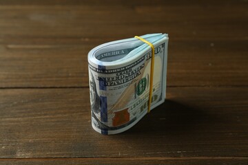 Bundle of dollar banknotes on wooden table