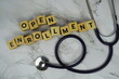 © may1985 - Open Enrollment with wooden blocks alphabet letters and stethoscope on marble background