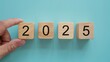 © Sun - 2025 wooden block for newyear purpose on the center light blue background.