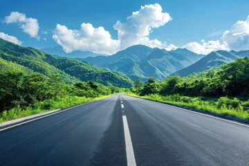 Canvas Print - A long stretch of empty road winding through mountains in the distance