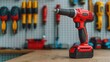 © Intelligent Horizons - Closeup view of a red cordless electric screwdriver or drill being charged on a cluttered workbench in a garage or industrial workshop setting