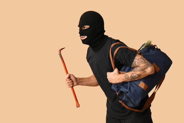 Poster - Male thief with crowbar and bag of money on beige background