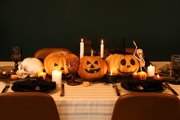 Wall Mural - Festive table setting for Halloween celebration with pumpkins and burning candles at evening