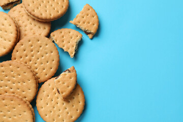 Wall Mural - Tasty sandwich cookies on light blue background, top view. Space for text