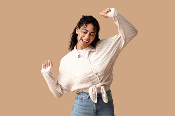 Poster - Happy young African-American woman in stylish striped collar shirt on brown background